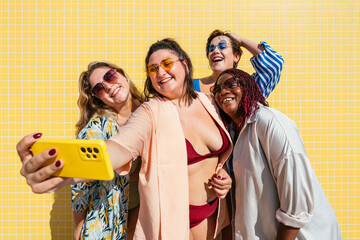 Obraz premium Group of beautiful plus size women with swimwear bonding and having fun at the beach - Group of curvy female friends enjoying summertime at the sea, concepts about body acceptance and body positive 
