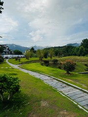Kamienna ścieżka prowadząca przez zielony park z górskim krajobrazem w Anhui, Chiny © Magorzata