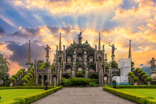 The Baroque Palazzo Borromeo on the island of Isola Bella on Lake Maggiore in Italy. with a beautiful sunset sky and sun rays.