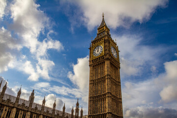 Obraz premium The Big Ben tower and Palace of Westminster under a cloudy blue sky in London