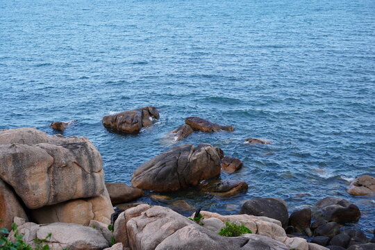 Granite boulders and rocks in clear blue sea water at Hon Chong, rocky coastline of Nha Trang, Vietnam
