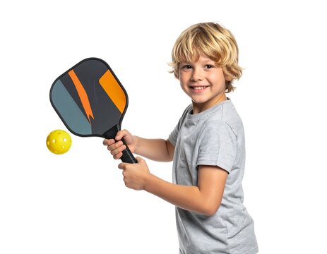 A young boy with blond hair holding a colorful pickleball paddle and a yellow ball