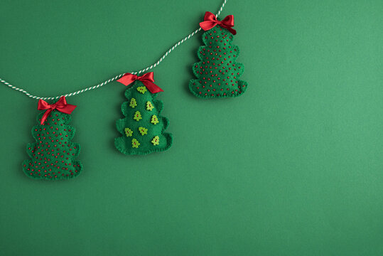 Handcrafted felt christmas tree garland against a green background