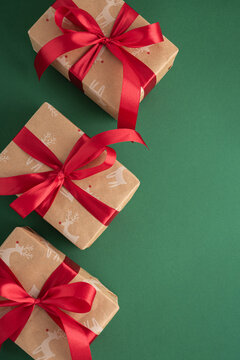 Christmas gifts wrapped in craft paper with red ribbons