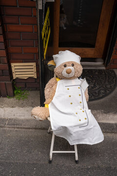 Teddy bear sitting on a chair, advertising and promoting a restaurant in Tokyo Japan