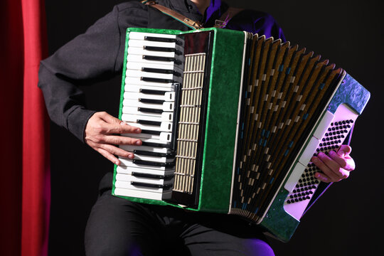 Man playing piano accordion on stage, closeup