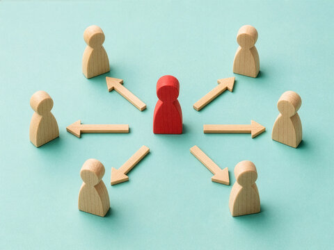 Wooden Figure Leader Directing Team Members with Arrows: Concept of Leadership, Delegation, Influence, and Business Management Strategy