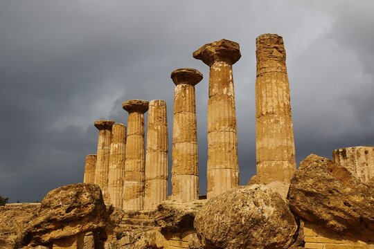 Row of columns, chapter, Heracles temple, dark clouds, sun, thunderstorm atmosphere. Valley of the temples, valle dei templi, Agrigento, Sicily, Italy