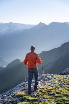 Hiker enjoying the mountain panorama in the morning, Venediger group, behind Dreiherrenkopf, Simonysitze and Gro&szlig;er Geiger, Hohen Tauern, Austria