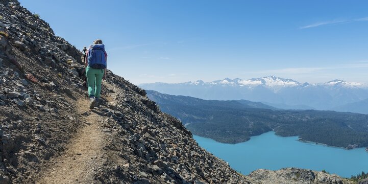 View from Panorama Ridge Hiking Trail, Hiker at Garibaldi Lake, Turquoise Glacial Lake, Guard Mountain and Deception Peak, Garibaldi Provincial Park, British Columbia, Canada