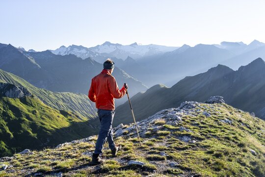 Hiker enjoying the mountain panorama in the morning, Venediger group, behind Dreiherrenkopf, Simonysitze and Gro&szlig;er Geiger, Hohen Tauern, Austria