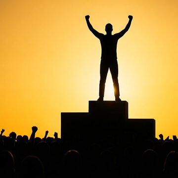 Silhouette of person on podium with arms raised in victory