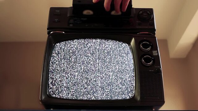 Hand Inserting VHS Tape into VCR to Turn On Retro TV Green Screen - 4K