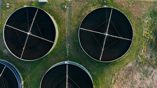 Aerial view of circular sedimentation tanks at wastewater treatment facility. Modern sewage treatment plant with circular storages and sedimentation ponds. Sustainable water management