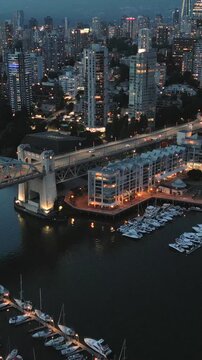 Downtown of Vancouver at night, skyscrapers and traffic on the roads. 