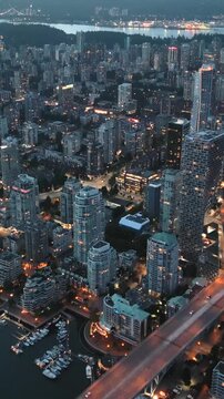 Downtown of Vancouver at night, skyscrapers and traffic on the roads. 