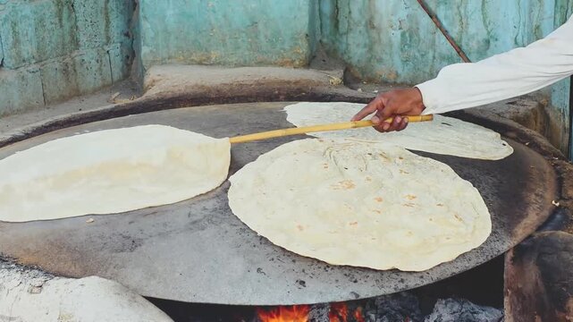 Cooking tortillas on a comal over an open flame