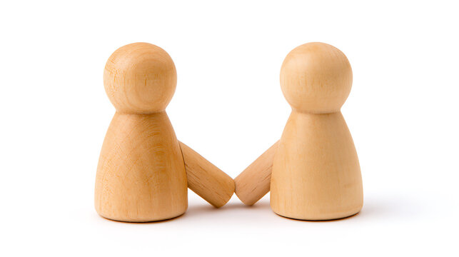Two wooden peg dolls lean against each other, symbolizing connection, teamwork, and support on a clean white background with subtle shadows, simple yet profound