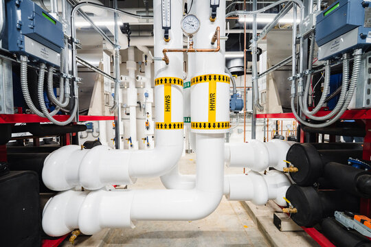 Commercial Mechanical Room with Complex White Insulated Piping and HHW Gauges