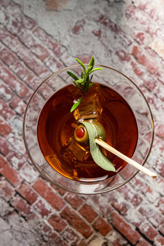 topviiew of a cocktail with sage, rosemary and olive to celebrate a birthday or new year.