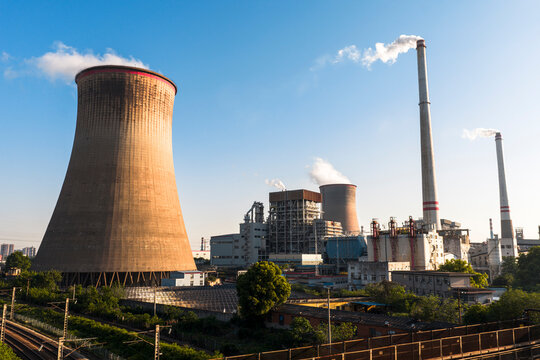 Wuhan Thermal Power Plant featuring gaint nuclear-style cooling towers and smokestacks, emitting heavy steam. It uses ultra-low emission, cogeneration for green energy transition. China.	