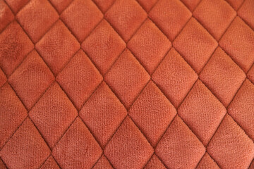 Obraz premium Orange velvet quilted fabric creating diamond pattern