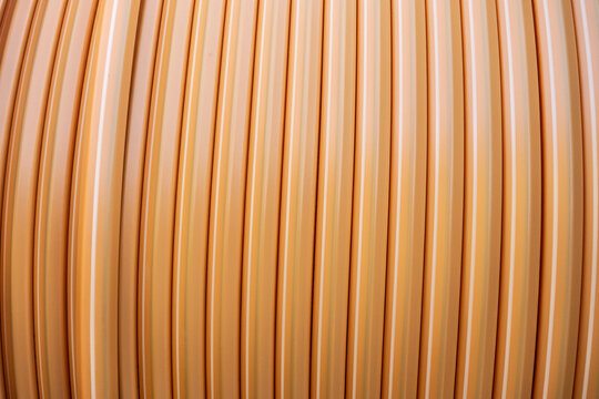 Orange electric cable conduit winding on a reel