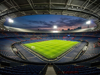 Naklejka premium Empty football stadium under bright lights at sunset