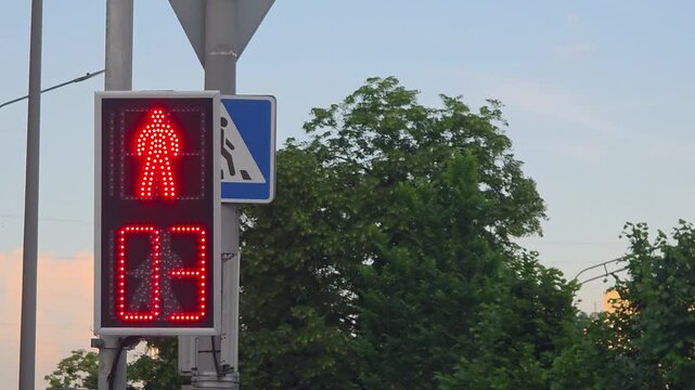 Pedestrian signal countdown at a busy intersection in an urban area during evening time