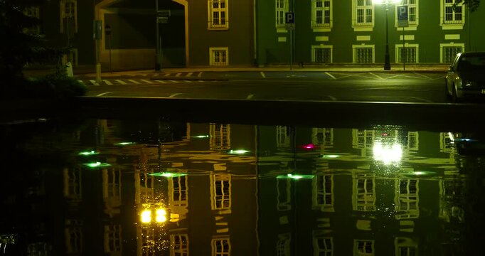 Illuminated Pond Reflecting Szczecin City Hall at Night - Jasne Błonia Square in Szczecin, Poland, at approximately 1:45 a.m. Gently rippling water in an illuminated pond reflects the lights 