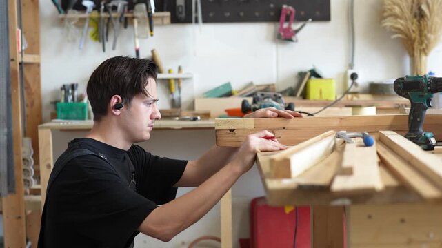 Working process in restoration workshop, concentrated man woodworker restoring old window frame, focused master carefully selecting wooden patch detail similar species and age and checks fitting.