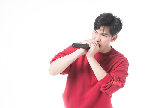 Young man beatboxing into microphone in studio