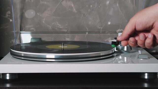 Vinyl Record Player Hand Placing Stylus on LP Record and Closing Dust Cover, Turntable Playing Analog Music, HiFi Audio, Retro Listening Experience at Home.