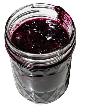 Glass jar of homemade blueberry jam, or dessert topping, isolated, delicious summer food treat
