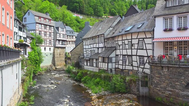 Beautiful town of Monschau in the Eifel region of western Germany. Riverside half timbered houses and castle ruins. Slow upward panning motion.