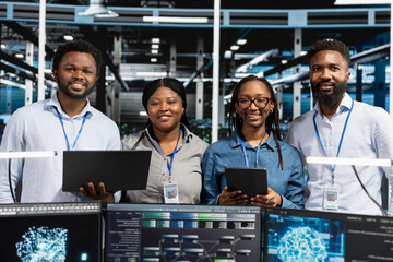 Happy data center team reviews data analysis graph to reduce equipment failure.