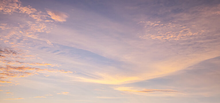 Beautiful sunset sky background with soft pastel orange light and dramatic golden sun glow for panoramic travel mockup design
