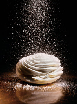 Marshmallow with Powdered Sugar Falling on Dark Background