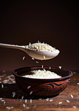 Wooden Spoon with Raw Long Grain Rice over Rustic Ceramic Bowl