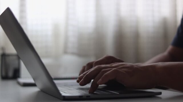 Businessman typing on laptop keyboard. Man hand coding quickly on laptop. Software developer, programmer, freelancer or office worker working on computer, chatting, writing message at home office.