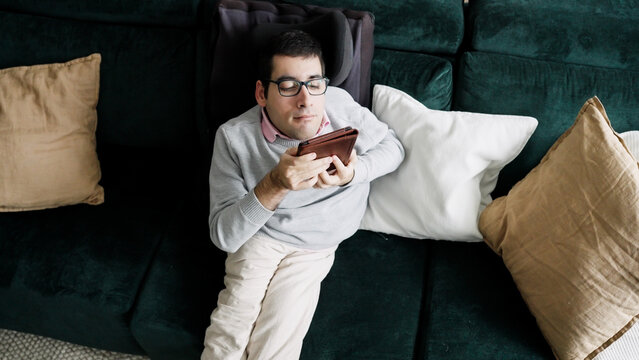 Person with a physical disability enjoying leisure time, relaxing at home, and engaging with an e reader device