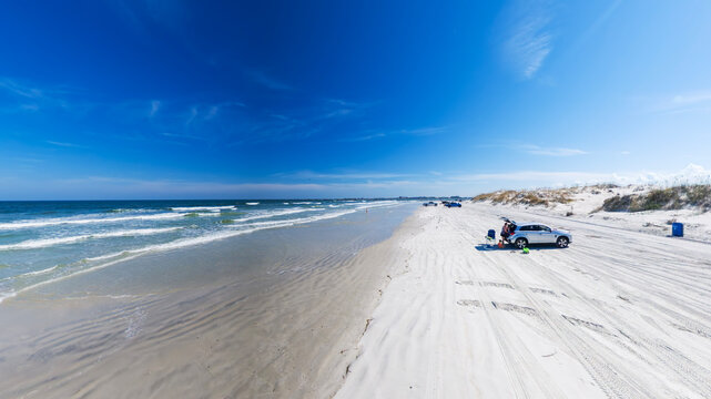 Florida Atlantic Beach With Ocean Waves And Parked Vehicles Under Clear Blue Sky