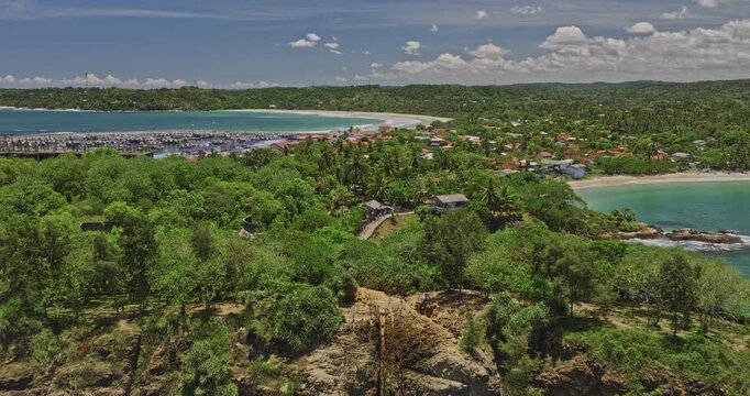 Kudawella Sri Lanka Aerial v8 cinematic drone flyover rocky shore capturing Hummanaya blowhole, fishing village, marina harbor, sandy beach views on a sunny day - Shot with Mavic 3 Cine - April 2023