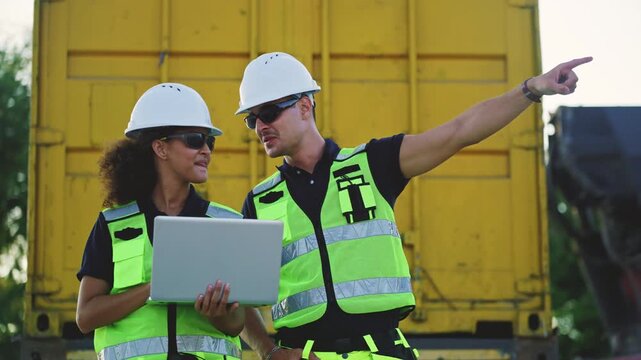 Logistics workers and engineers in safety vests using laptop while checking inventory at container terminal, representing industrial management, international trade, and supply chain technology.