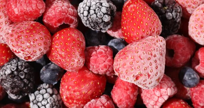 Mix of frozen berries as background, spinning. Closeup view