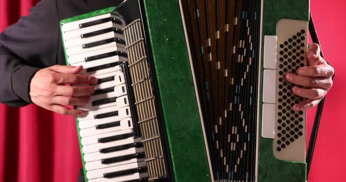 Man playing piano accordion on stage, closeup