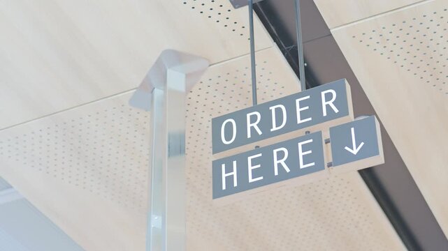 Hanging order here directional sign at restaurant counter
