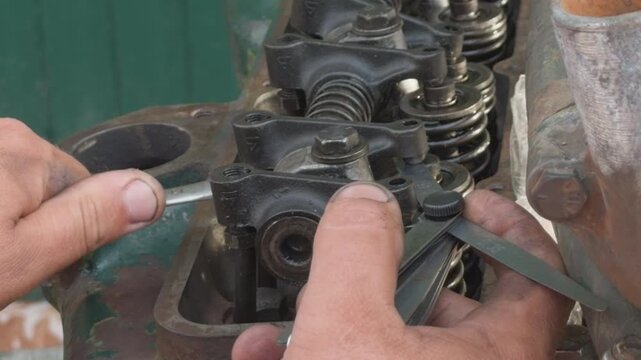 Mechanic adjusting valve clearance on engine cylinder head