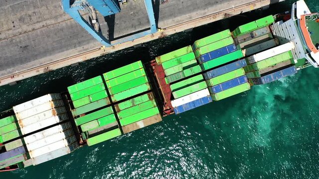 Aerial view of the container ship Veronica B, maneuvering for dock with a tug in the port of Alicante, in the Mediterranean coast of Spain.