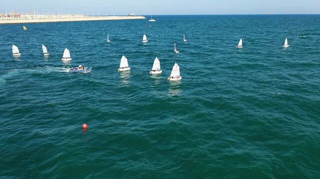 Aerial view of groupes of Optimist Class sailboats before the starting of a regatta in Alicante, in the Mediterranean coast of Spain.